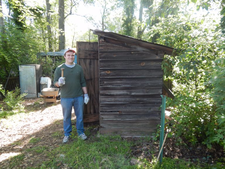 Dylan Stearns poses with an outbuilding.