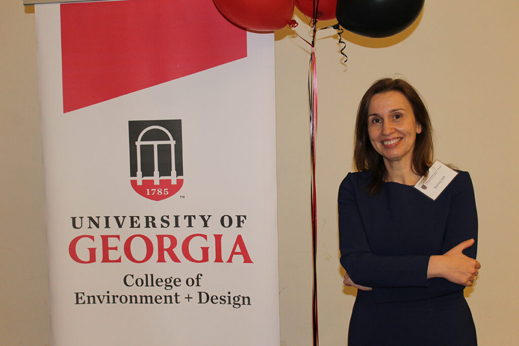 Sonia Hirt stands by balloons and a UGA CED banner.