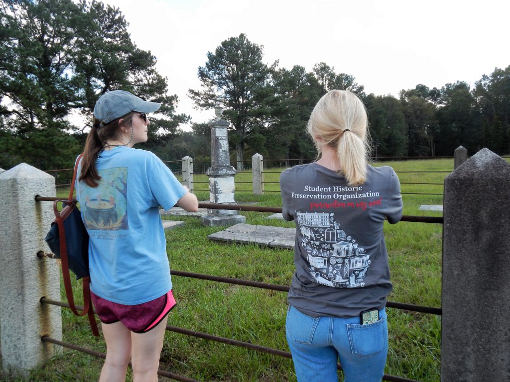 Students standing outside of cemetery