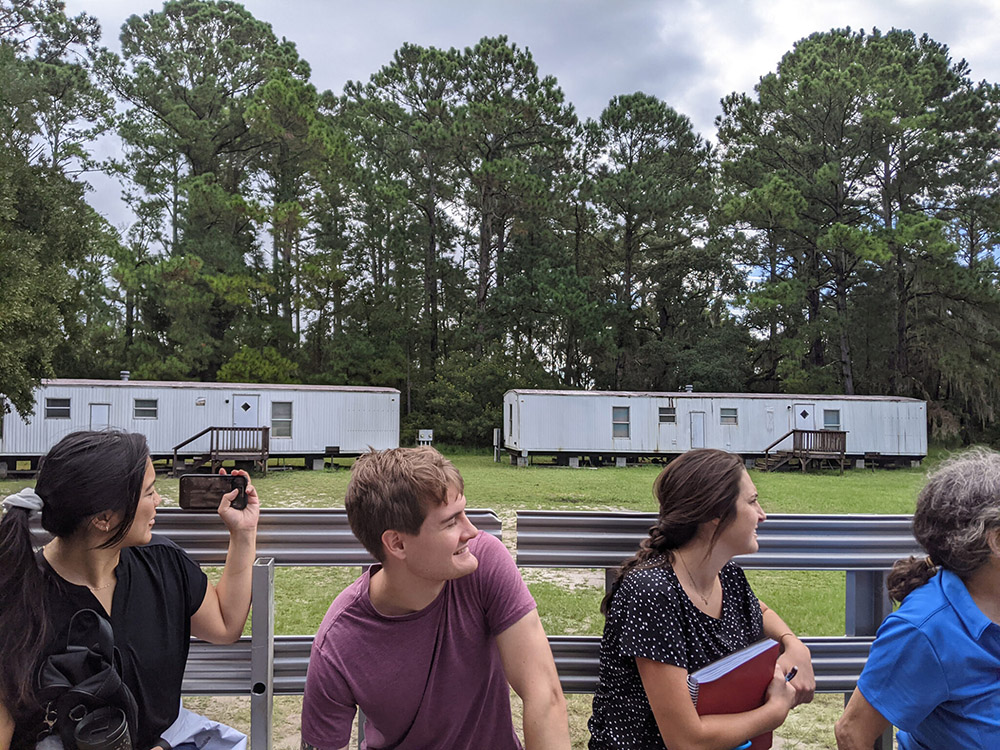 Students riding on a flatbed truck looking at housing options at the Marine Institute.