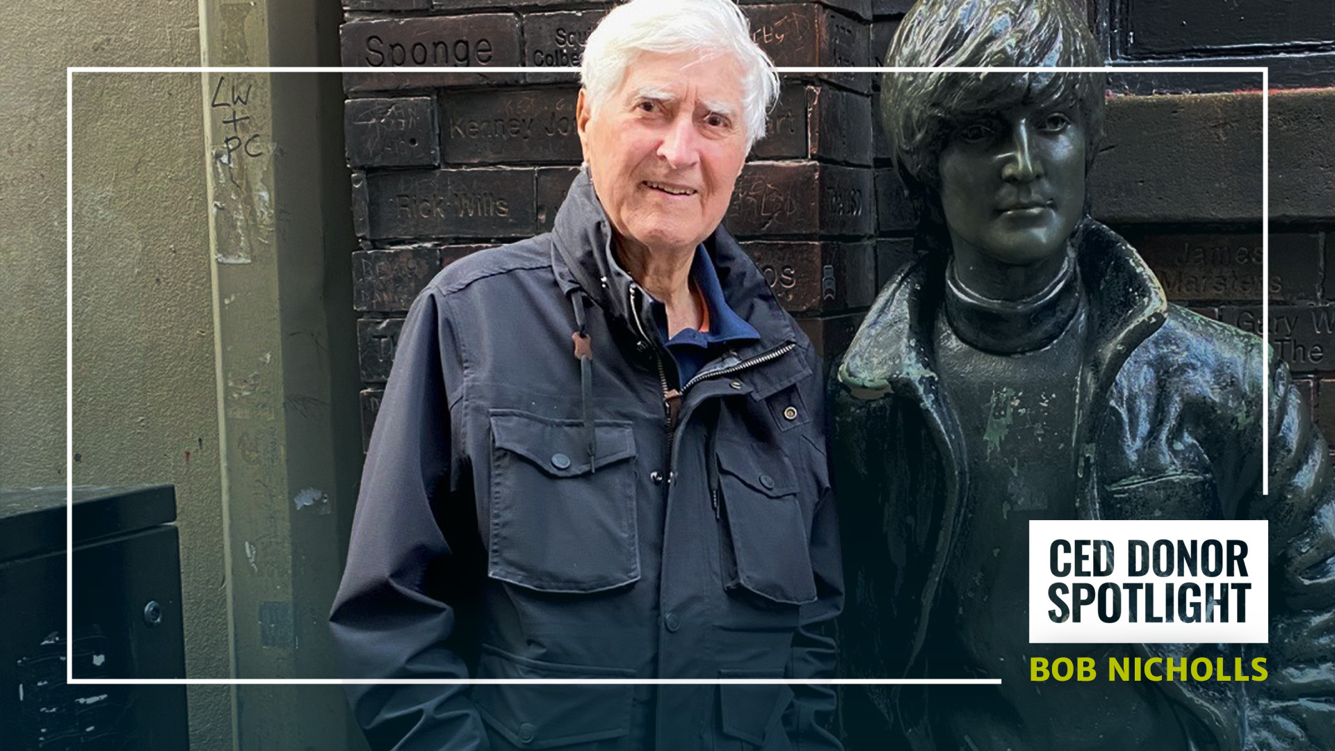 Bob Nicholls stands with a statue of John Lennon.