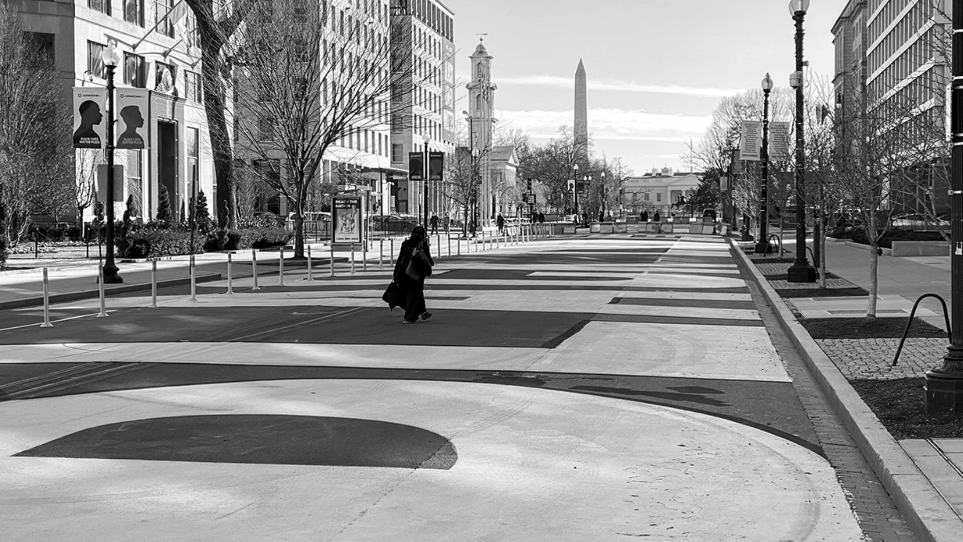 A street scape in a city with a single person in the middle