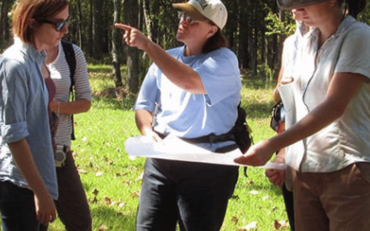 UGA CED students work with Cari Goetcheus in a field.