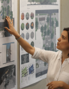 A woman points to a poster on a wall at the UGA CED.