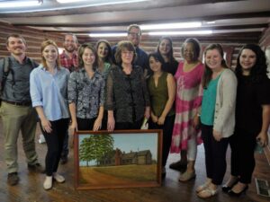 Students pose with Ms. Leila and Millie Copelan and a picture of her family home, one of the buildings in the proposed National Register District.