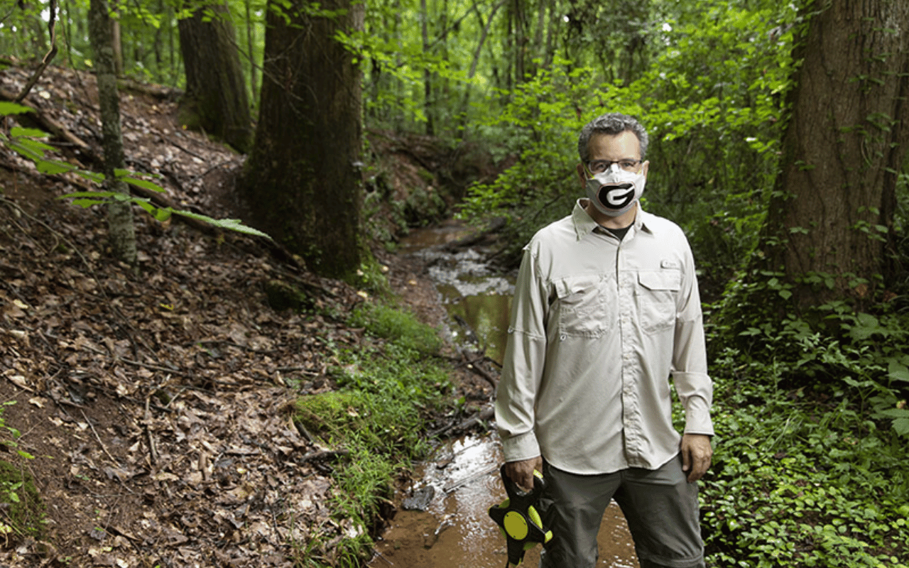 Portrait of Jon Calabria outside with a UGA mask on.