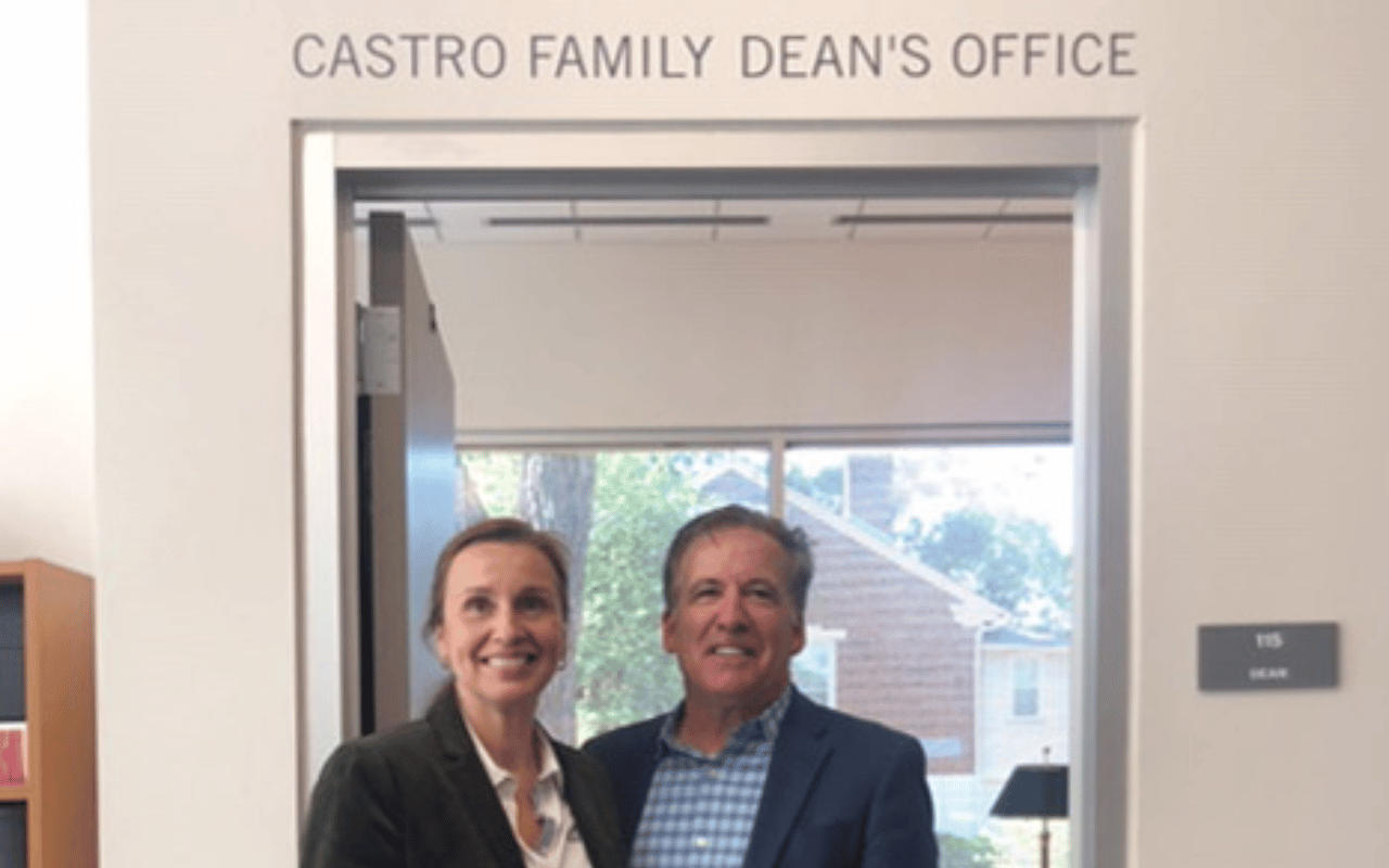 Sonia Hirt and Ed Castro stand in front of the Castro Family Dean's Office.