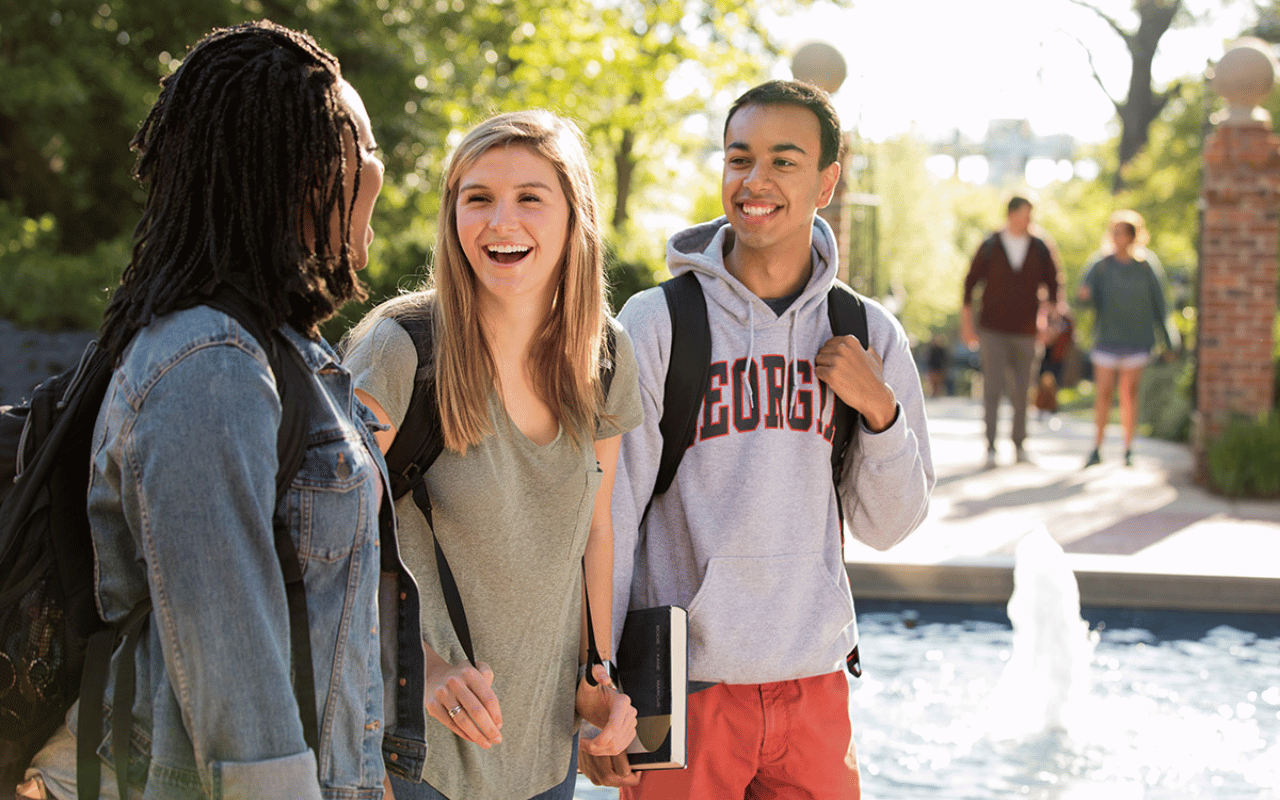 UGA students walk outside near a fountain.