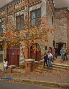Students walking down the steps of the Tanner Building in fall.