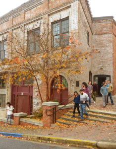 Students walking down the steps of the Tanner Building in fall.