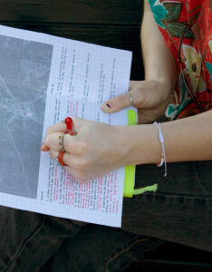 Close-up of a student writing field notes on graph paper with a printed site map.