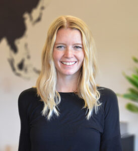 Portrait of a Devon King, Principal at EDSA’s Fort Lauderdale office, wearing a black top, smiling in an indoor setting.