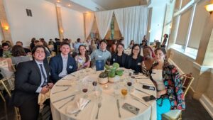 Group of UGA and LSU landscape architecture students seated together at a formal banquet table, smiling for a photo during an awards event.