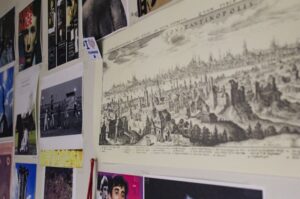 Collage of art and map prints pinned to a wall, including an old map labeled “Constantinopolis”.