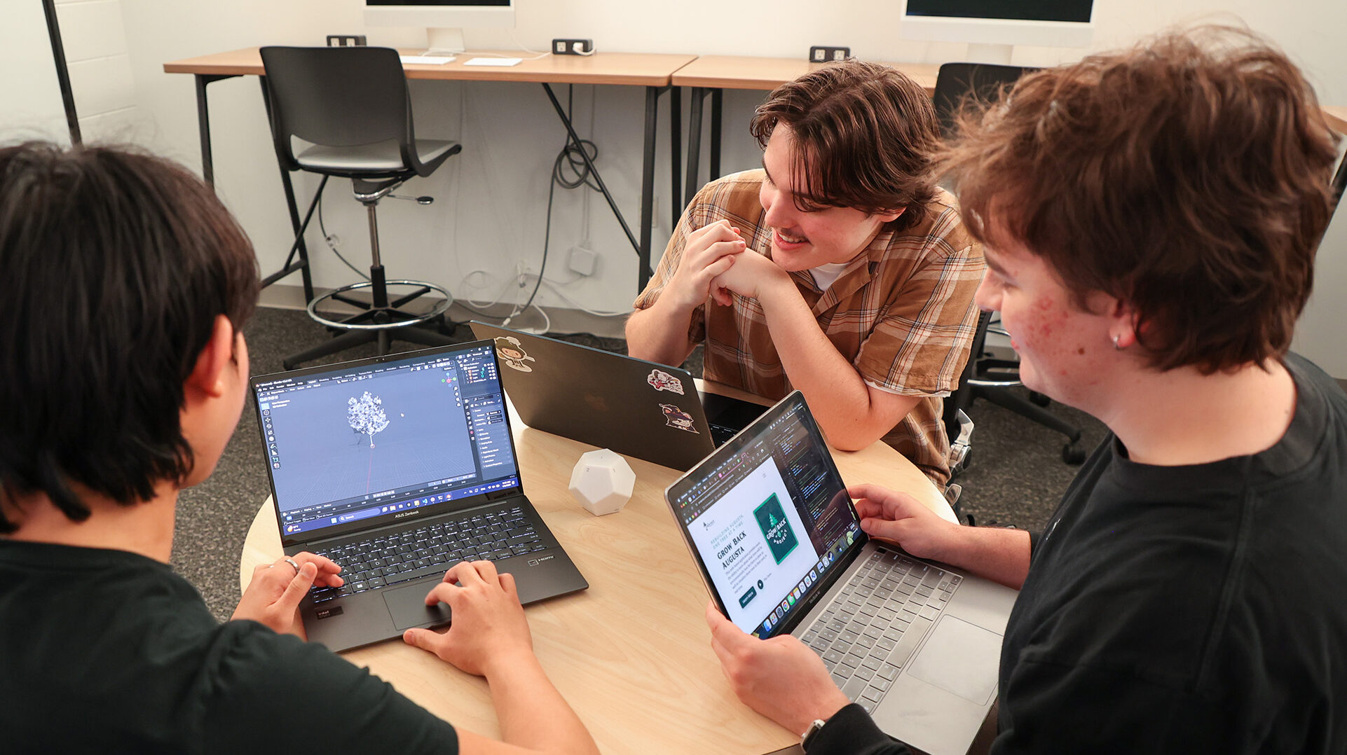 group of students collaborating over laptops